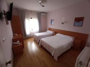 a hotel room with two beds and a television at HOTEL EL MOLINO DE PANCORBO in Pancorbo