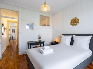 une chambre avec un grand lit blanc et un bureau dans l'établissement Le Coquet de Pasteur - À 5 minutes à pied de Nancy Thermal, à 10 min du campus ARTEM, à Nancy 8 autres photos