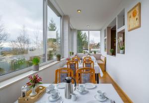 een eetkamer met een tafel, stoelen en ramen bij Hotel Riesberghof in Lindberg
