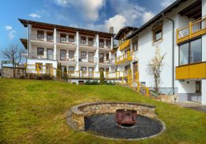 a building with a fire pit in front of it at Hotel Riesberghof in Lindberg