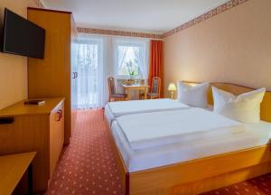 a hotel room with a large bed and a table at Hotel Riesberghof in Lindberg