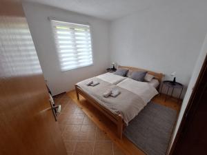 a bedroom with a bed with two pillows and a window at Apartman Emanuel in Jajce