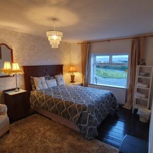 a bedroom with a bed and a large window at St Martins Old Schoolhouse Ballyroe Tralee in Tralee