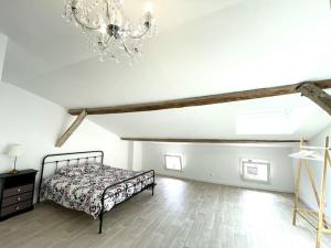 una camera con letto e lampadario a braccio di Maison familiale rénovée au cœur de la Bastide ! a Castillonnès