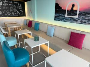ein Restaurant mit Tischen, Stühlen und einer Tafel in der Unterkunft Onmood Cala Ratjada - New Opening 2024 in Cala Ratjada
