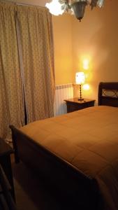 a bedroom with a bed and a lamp on a table at B&B Serena in Casapulla