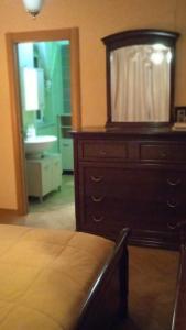 a bedroom with a dresser with a mirror and a sink at B&B Serena in Casapulla