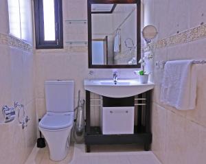 een badkamer met een toilet, een wastafel en een spiegel bij Hotel La Casa Blanca in Tetouan
