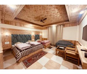 1 dormitorio con 2 camas y TV. en Sunrise Guest House en Kasol