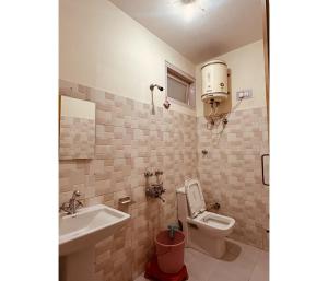 La salle de bains est pourvue de toilettes et d'un lavabo. dans l'établissement Sunrise Guest House, à Kasol