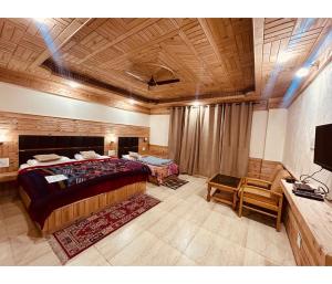 Dormitorio con cama, escritorio y TV en Sunrise Guest House en Kasol