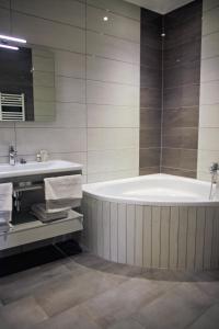 un bagno con vasca e lavandino di Hotel-Restaurant St-Christophe a Belfort