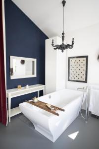 baño con bañera blanca y pared azul en Chasa Alba, en Scuol