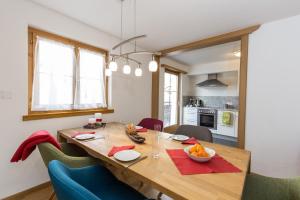 eine Küche und ein Esszimmer mit einem Holztisch und Stühlen in der Unterkunft Chasa Praem, Scuol in Scuol