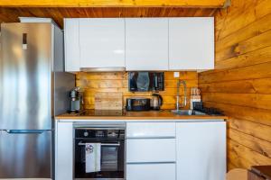 uma cozinha com armários brancos e um frigorífico de aço inoxidável em Wood House Amazing View Douro em Raiva