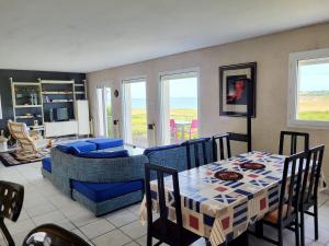 a living room with a table and a couch at 622-Ker An Enez la plage au bout du jardin in Esquibien