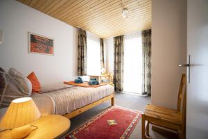 シュクオルにあるFeriensiedlung Trü 18のベッドルーム1室(ベッド1台、大きな窓付)