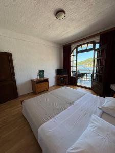ein Schlafzimmer mit einem großen Bett und einem großen Fenster in der Unterkunft Villa Samac in Trogir