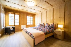1 dormitorio con 1 cama y 1 silla en una habitación en Chasa Schilana 84 en Ramosch