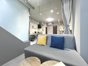 a bedroom with a bed with blue and yellow pillows at Aizumi Hostel in Tokyo