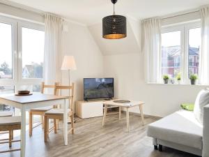 Una sala de estar con una mesa y un televisor. en Frau Zander, en Zingst