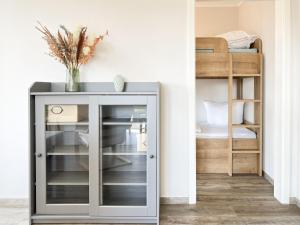 Armario de cristal en una habitación con litera en Frau Zander, en Zingst