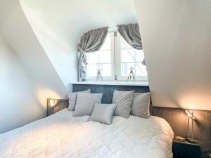 um quarto com uma cama branca e uma janela em Ferienhaus Hahn em Wustrow