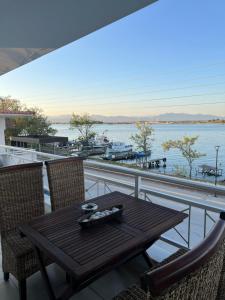 a table and chairs on a balcony with a view of the water at Anna Apartments in Keramotí