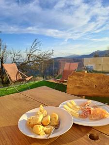 dos platos de comida sentados en una mesa de madera en Apartment Panorama Val di Non, en San Felice