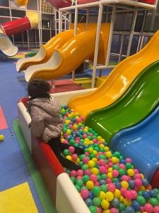 a young child sitting on a slide in an indoor playground at BULAND HEIGHTS in Murree