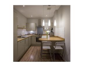 a kitchen with a wooden table and chairs in it at The Lane Apartment in Edinburgh