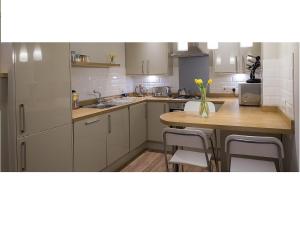 a kitchen with a wooden table and a table with chairs at The Lane Apartment in Edinburgh +16 photos