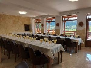 uma grande sala de banquetes com uma mesa longa e cadeiras em La Lacuri em Sovata