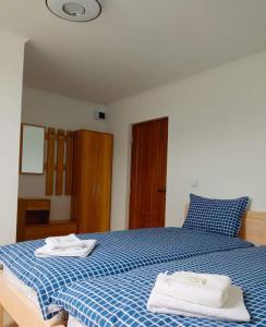 um quarto com uma cama azul e branca com toalhas em La Lacuri em Sovata