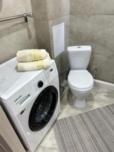 - un lave-linge dans la salle de bains pourvue de toilettes dans l'établissement 1 комнатная квартира, Уральск, à Uralsk