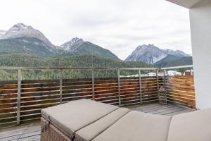 a balcony with a couch and mountains in the background at Chasa Vista Lischana in Scuol