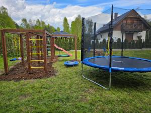 a playground with a trampoline in the grass at Domek letniskowy - niebieski całoroczny in Stegers