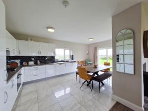 a kitchen with a table and a dining room at Foregloss Cottage in Ballyconneely