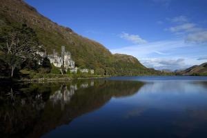 une grande étendue d'eau avec un bâtiment sur le côté d'une montagne dans l'établissement Foregloss Cottage, à Ballyconneely