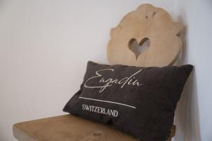 una almohada en una estantería de madera con un corazón en ella en Chasa Riatsch, en Ardez
