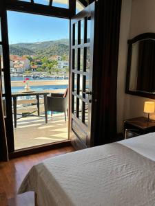 a bedroom with a bed and a balcony with a table at Villa Samac in Trogir