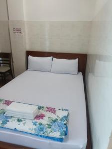 a bed in a small room with a white bedvisor at Hotel Phương linh in Ho Chi Minh City