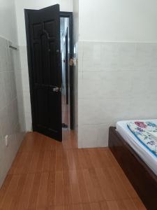 a room with a black door and a wooden floor at Hotel Phương linh in Ho Chi Minh City