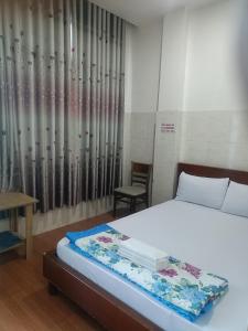 a bedroom with a bed and a table and a chair at Hotel Phương linh in Ho Chi Minh City