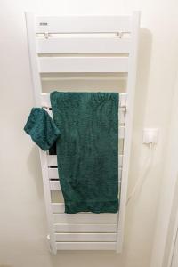 ein grünes Handtuch auf einem weißen Handtuchhalter in der Unterkunft studio lumineux in Choisy-le-Roi