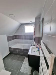 a bathroom with a sink and a bath tub at 710-Villa Trescadec a 100m de la plage in Audierne