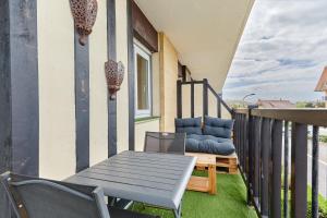 a patio with a chair and a bench on a balcony at MYA’S Family - Joli appartement 100m de la plage in Villers-sur-Mer