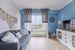 a living room with a couch and a large window at MYA’S Family - Joli appartement 100m de la plage in Villers-sur-Mer