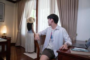 a man sitting at a desk next to a woman at Athena Hotel in Pakse