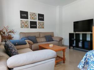 sala de estar con sofá y mesa en Vivienda Turística Ronda del Carmen, en Bujalance